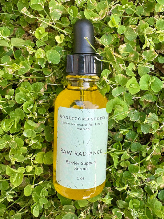 Bottle of Raw Radiance Barrier Support Serum from Honeycomb Shores on a green leafy background