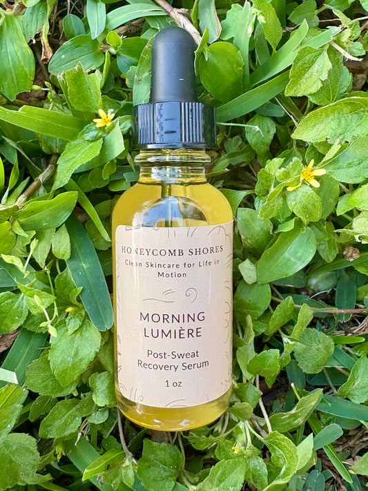 Bottle of 'Morning Lumérie' serum from Honeycomb Shores on a grassy background
